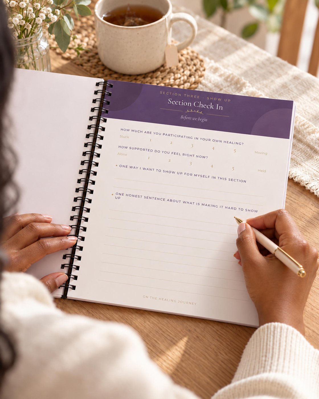 A woman writing in The Healing Girl workbook, on a Section Check In page